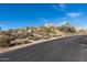 Street view of lot in desert community showcasing natural desert vegetation and boulder outcroppings at 11130 E Rolling Rock Dr, Scottsdale, AZ 85262