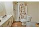 Cozy bathroom featuring a shower with a floral curtain, toilet, and vanity with white cabinetry at 120 N Val Vista Dr # 230, Mesa, AZ 85213