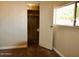 A bedroom with neutral carpet, a closet with wood shelving and a window at 120 N Val Vista Dr # 230, Mesa, AZ 85213
