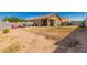 A spacious backyard with dirt and minimal grass, a covered patio, and a privacy wall at 12033 W Davis Ln, Avondale, AZ 85323