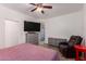 This bedroom boasts a ceiling fan, TV, dresser, and an upholstered armchair for comfortable viewing at 12033 W Davis Ln, Avondale, AZ 85323