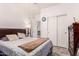 A simple bedroom with wood laminate flooring, dark wood dresser, closet, and floral bedding at 12033 W Davis Ln, Avondale, AZ 85323