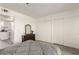 Bright bedroom featuring wood-look floors, a dresser with mirror and walk-in closet at 12123 W Bell Rd # 339, Surprise, AZ 85378