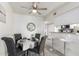 Cozy dining area with gray upholstered chairs, modern mirror, and a ceiling fan at 12123 W Bell Rd # 339, Surprise, AZ 85378