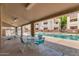 Community pool with seating, covered patio area and mature landscaping at 12123 W Bell Rd # 339, Surprise, AZ 85378