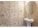 Stylish powder room features unique wallpaper and a pedestal sink at 1367 S Country Club Dr # 1276, Mesa, AZ 85210