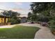 Lush backyard featuring a well-manicured lawn, mature trees, and a charming water fountain at 1522 W Myrtle Ave, Phoenix, AZ 85021