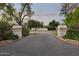 Grand entrance featuring stone pillars with address markers and a private driveway lined with greenery at 1522 W Myrtle Ave, Phoenix, AZ 85021