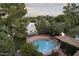 Aerial shot of a well-maintained circular pool, surrounded by a brick patio and lush green trees at 1522 W Myrtle Ave, Phoenix, AZ 85021