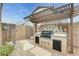 Custom barbecue grill with tiled backsplash and pergola, set in a landscaped backyard at 15962 W Statler St, Surprise, AZ 85374