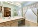 Bathroom with an extended vanity, large mirror, and shower-tub with curtain at 15962 W Statler St, Surprise, AZ 85374