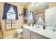 Bright bathroom featuring a large mirror, vanity, toilet, and decorative shower curtain at 15962 W Statler St, Surprise, AZ 85374