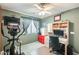 Green bedroom showcasing an elliptical machine, ceiling fan, and a functional workspace with storage at 15962 W Statler St, Surprise, AZ 85374