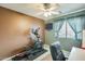 Workout bedroom features an elliptical machine, wall-mounted TV, and window view at 15962 W Statler St, Surprise, AZ 85374