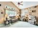 Charming living room featuring a vaulted ceiling, ceiling fan, large windows and rustic decor at 15962 W Statler St, Surprise, AZ 85374