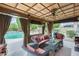 Luxurious covered patio with comfortable seating, fan, curtains and view of the pool at 15962 W Statler St, Surprise, AZ 85374