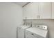 Bright laundry area featuring a modern washer, dryer and upper cabinets at 17514 N Rainbow Cir, Surprise, AZ 85374