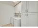 Well-lit laundry room equipped with modern appliances and cabinet storage at 17514 N Rainbow Cir, Surprise, AZ 85374