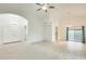 Bright, open living room features tile floors, ceiling fan, and arched doorways, offering modern comfort at 17514 N Rainbow Cir, Surprise, AZ 85374