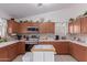 Well-equipped kitchen featuring wood cabinetry, tile backsplash, and a central island at 1758 E Birch St, Casa Grande, AZ 85122
