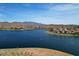 Scenic aerial view of a lake surrounded by homes and rolling desert mountains at 18233 W Hope Dr, Goodyear, AZ 85338