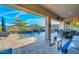This covered patio offers a stunning view of the pool, water feature, and mountain scenery, making it ideal for relaxation at 18233 W Hope Dr, Goodyear, AZ 85338