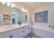 Bright bathroom with double vanity, soaking tub, textured tile, and separate glass shower at 18233 W Hope Dr, Goodyear, AZ 85338