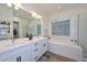 Bright bathroom with double vanity, soaking tub, textured tile, and separate glass shower at 18233 W Hope Dr, Goodyear, AZ 85338