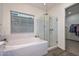 Elegant bathroom featuring a soaking tub, glass-enclosed shower, and modern finishes at 18233 W Hope Dr, Goodyear, AZ 85338