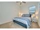 Cozy bedroom featuring a full bed, neutral carpet, ceiling fan, and a window at 18233 W Hope Dr, Goodyear, AZ 85338