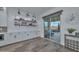 Bright dining area with sliding glass doors, custom cabinets, display shelving and wine storage, flooded with natural light at 18233 W Hope Dr, Goodyear, AZ 85338