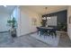 Stylish dining room featuring a modern light fixture, accent wall, and wood-look tile flooring at 18233 W Hope Dr, Goodyear, AZ 85338