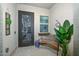 Cozy covered front patio with decorative door, bench and beautiful potted plants at 18233 W Hope Dr, Goodyear, AZ 85338