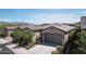 Inviting single-story home with desert landscaping, a two-car garage, and mountain views at 18233 W Hope Dr, Goodyear, AZ 85338
