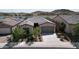 Beautiful home features a well-manicured front yard and tile roof with a lake in the background at 18233 W Hope Dr, Goodyear, AZ 85338