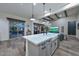 Spacious open kitchen with beamed ceilings, an island with a farmhouse sink, and stainless steel appliances at 18233 W Hope Dr, Goodyear, AZ 85338