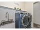 Well-equipped laundry room featuring a sink, shelving, and front-loading washer and dryer at 18233 W Hope Dr, Goodyear, AZ 85338