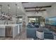 Open-concept living room with a kitchen island, wooden beams, and view to the outdoor patio at 18233 W Hope Dr, Goodyear, AZ 85338