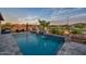 Backyard pool featuring custom waterfalls, fire bowls, a hot tub, and lake views at 18233 W Hope Dr, Goodyear, AZ 85338