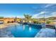 Backyard pool featuring custom waterfalls, fire bowls, a hot tub, and lake views at 18233 W Hope Dr, Goodyear, AZ 85338