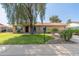 Charming single-story home with a lush green lawn, mature tree, and a welcoming front entrance at 19258 N 20Th Dr, Phoenix, AZ 85027