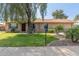 Charming single-story home with a lush green lawn, mature tree, and a welcoming front entrance at 19258 N 20Th Dr, Phoenix, AZ 85027