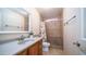 Bathroom featuring a vanity sink, toilet, and walk-in shower with decorative tile surround at 2002 S Apache Dr, Apache Junction, AZ 85120