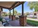Inviting covered front porch featuring brick accents, decorative columns, and comfortable seating at 20631 W Minnezona Ave, Buckeye, AZ 85396