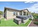 Backyard oasis featuring a hot tub with cover, surrounded by artificial turf, lush greenery and privacy walls at 20631 W Minnezona Ave, Buckeye, AZ 85396