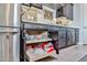 Close-up of the kitchen's slide out shelves, dark cabinets, stainless steel fridge, and patterned backsplash at 20631 W Minnezona Ave, Buckeye, AZ 85396