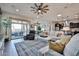 Open living room area with tile floors, neutral colored furniture, high ceilings, and a ceiling fan at 20631 W Minnezona Ave, Buckeye, AZ 85396