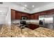 Kitchen featuring granite countertops, stainless steel appliances, and warm wood cabinets at 20660 N 40Th St # 1112, Phoenix, AZ 85050