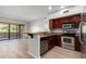 Bright kitchen with stainless appliances, granite countertops, wood cabinets, and an adjacent dining area at 20660 N 40Th St # 1112, Phoenix, AZ 85050