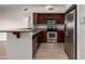 Well-equipped kitchen features stainless appliances, granite countertops, wood cabinetry, and an adjacent breakfast bar at 20660 N 40Th St # 1112, Phoenix, AZ 85050
